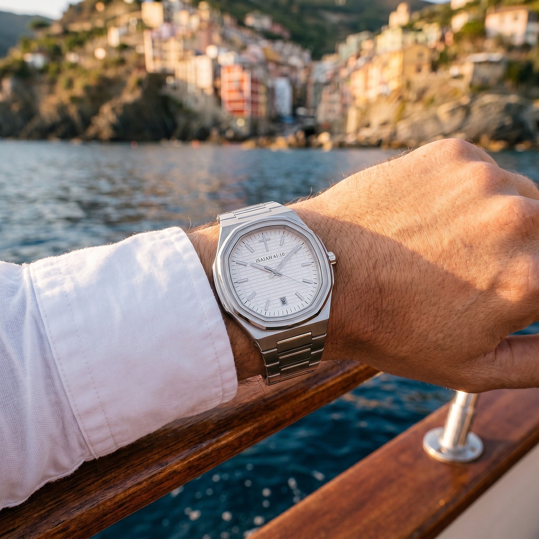 A wrist wearing the ISAIAH 41:10 watch by turquoise water
