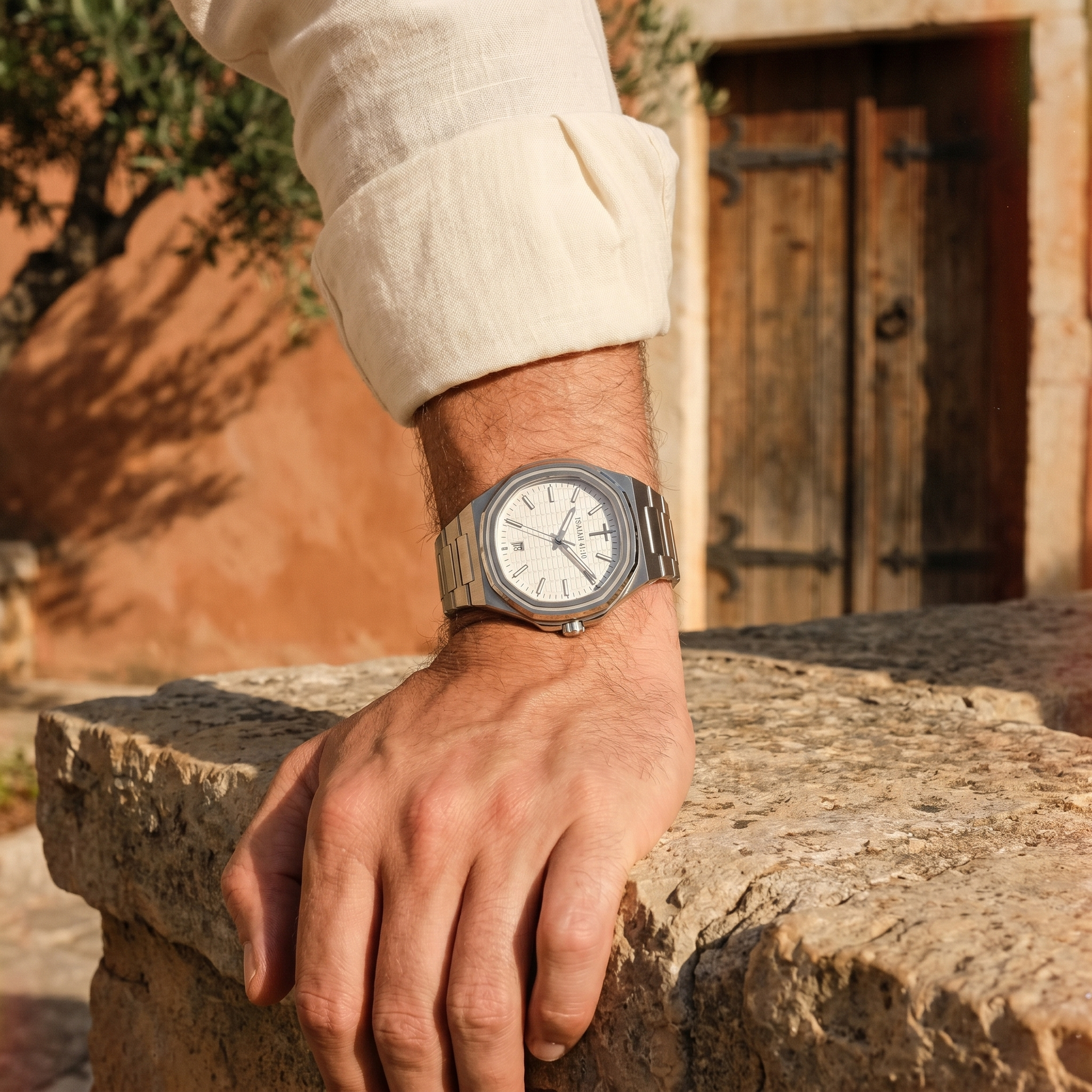 ISAIAH 41:10 watch on wrist resting on weathered stone wall outside ancient Mediterranean church, terracotta wall and old wooden door